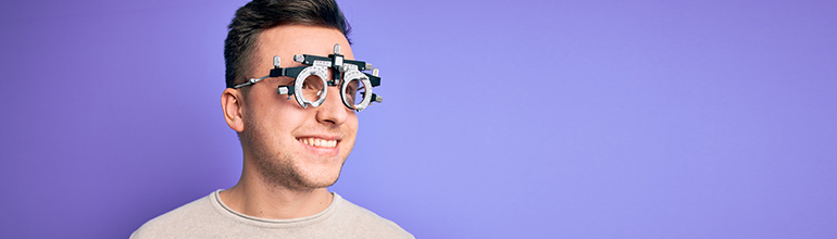man with optician test glasses on purple background