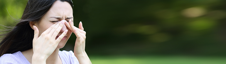 woman rubbing her eyes because of allergies