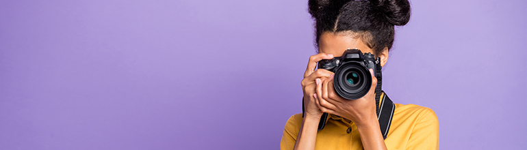 woman taking photos with camera on purple
