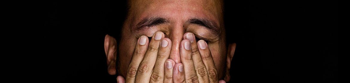 Man covering his eyes