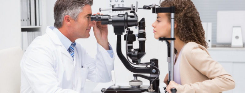 Optician examining patient's eyes