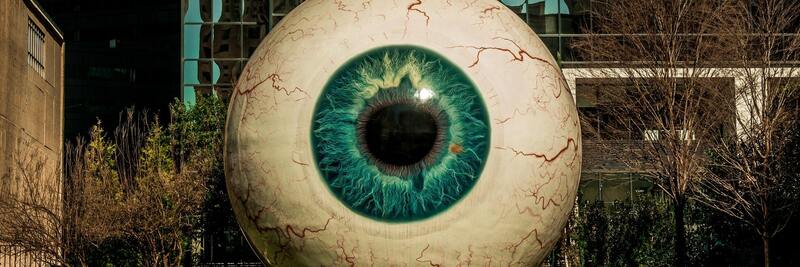 digital art of a big artificial eyeball in front of an urban background