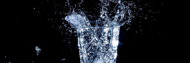 glass of water splashing over with black background