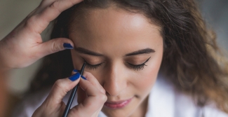 Makeup artist applying eyeliner to woman
