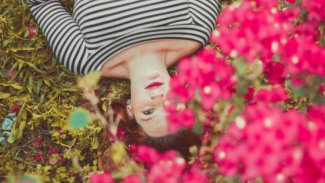 woman laying under pretty pink flowers