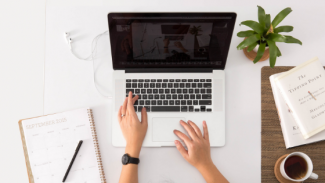 Student typing on Apple Mac