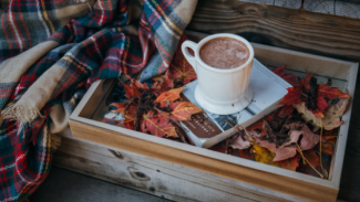 Autumn scene with a cup of hot chocolate, a book and a blanket