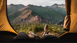 man camping, overlooking the mountains