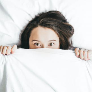 woman peeping head out from the duvet