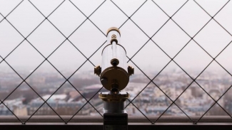 Tourist looking glass viewing cityscape