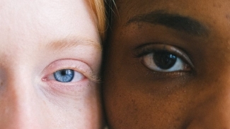 White person and black person next to each other with contrasting eye colours