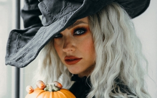Woman in witch hat and coloured contact lenses for Halloween