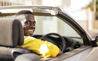 Man smiling in a convertible car