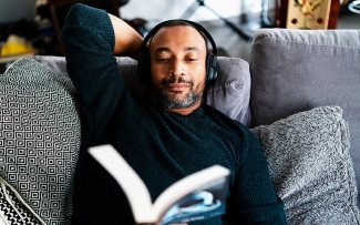 man reading a book and relaxing on couch