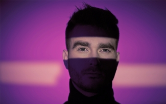man with purple lights background eyes showing