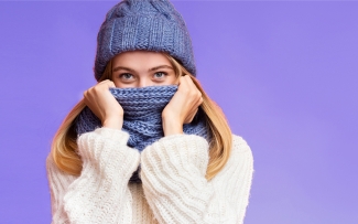 Woman with scarf and winter hat on purple background