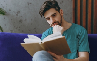 man reading a book on the sofa