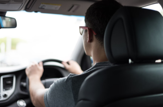 Man with glasses driving