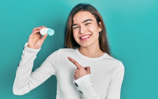 girl holding and pointing at a contact lens case