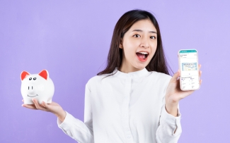 girl holding piggy bank and phone