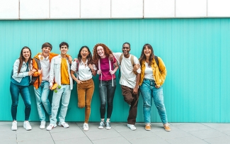 group of students on a teal background wall