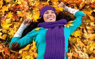 woman in pile of leaves autumn outside