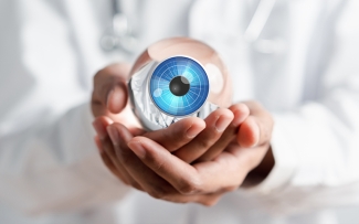 optician holding glass eye ball globe in hands