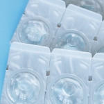 Rows of contact lens blister backs on blue background