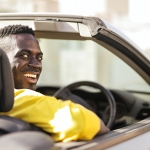 Man smiling in a convertible car