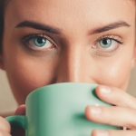 Girl with green eyes drinking from matching green mug