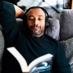 man reading a book and relaxing on couch