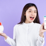 girl holding piggy bank and phone
