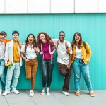 group of students on a teal background wall