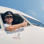 Pilot giving the thumbs up sign outside airplane window