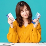 woman looking at monthly and daily contact lens boxes